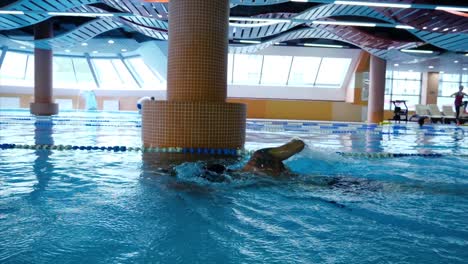 man swimming in indoor pool