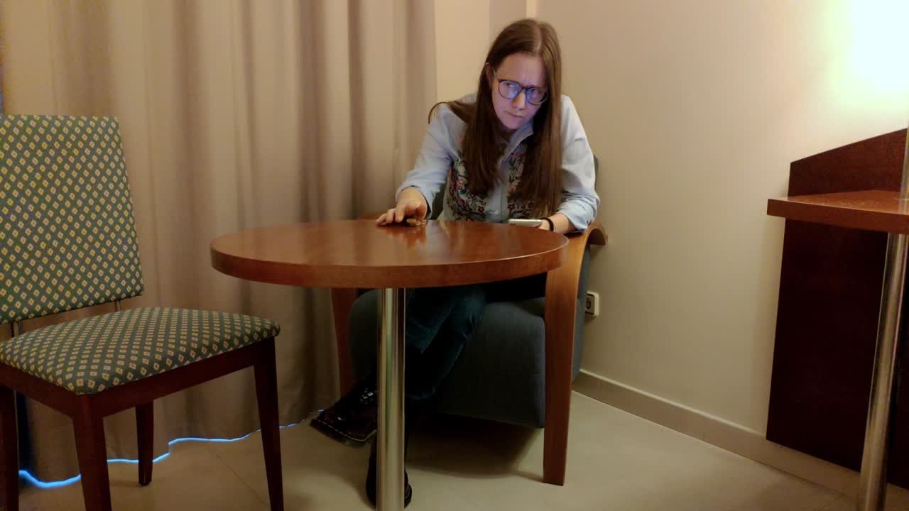 joven mirando su dinero y su teléfono inteligente