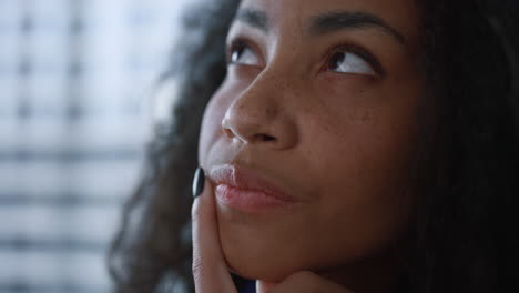 una mujer de negocios afroamericana enfocada pensando en ideas creativas en la oficina.