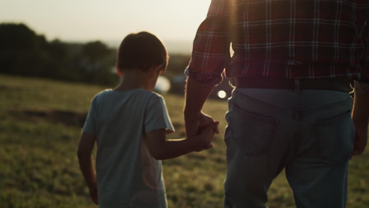 video de vista trasera del abuelo y el nieto caminando al atardecer