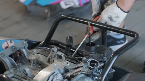el mecánico del servicio de carreras de karts vierte combustible en el tanque.