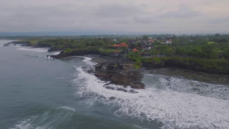 tanah lot hindu temple on offshore island on bali coast, aerial