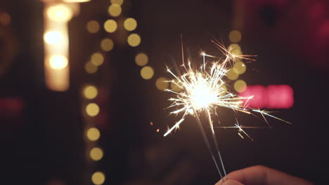 hand holding bright sparklers burning down