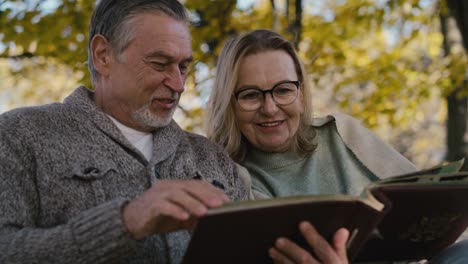 Senior-caucasian-couple-looking-at-old-photo-album