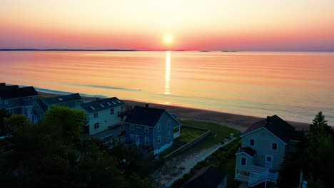 Los-Colores-Del-Atardecer-Se-Reflejan-En-Las-Olas-Del-Océano-Con-Vistas-A-Las-Casas-De-Playa.