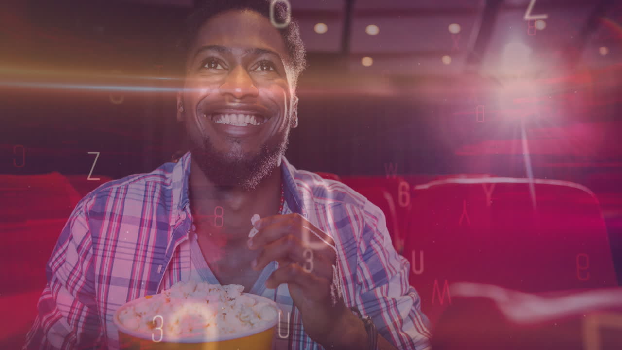 Animazione di lettere su un uomo afroamericano sorridente che mangia popcorn al cinema