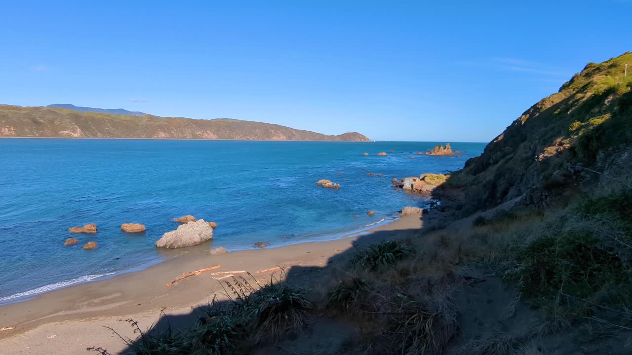 vista panorámica de las dunas de arena en la playa escarpada con vistas a la entrada del puerto de wellington en la capital de nueva zelanda, auteuil.
