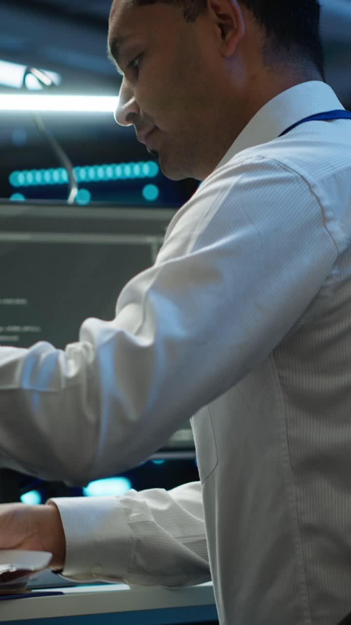 Focused IT Professional Coding on Computer in Server Room
