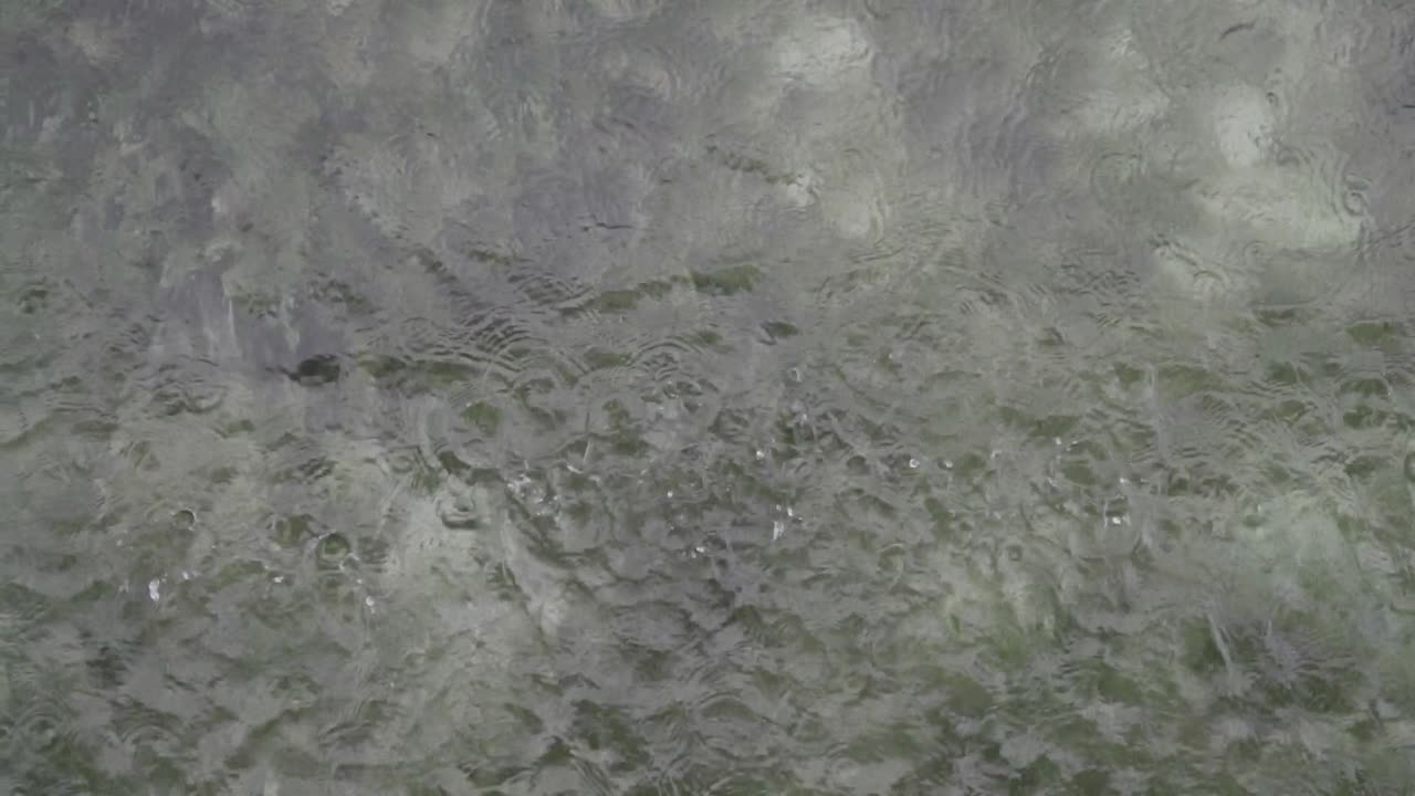 gotas de lluvia tocando la superficie del océano con arrecifes de coral debajo