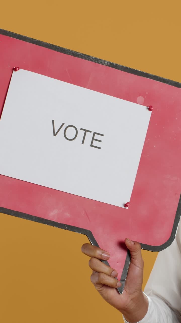 Close-up of Hand Holding 'Vote' Sign for Election