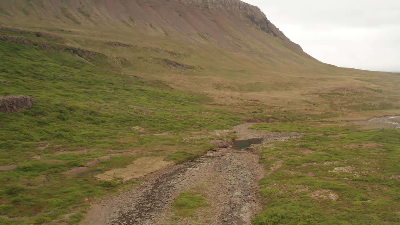 Ripide colline dei fiordi occidentali dell'Islanda in una giornata nuvolosa, ripresa da drone.