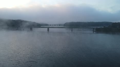 misty morning bridge over river