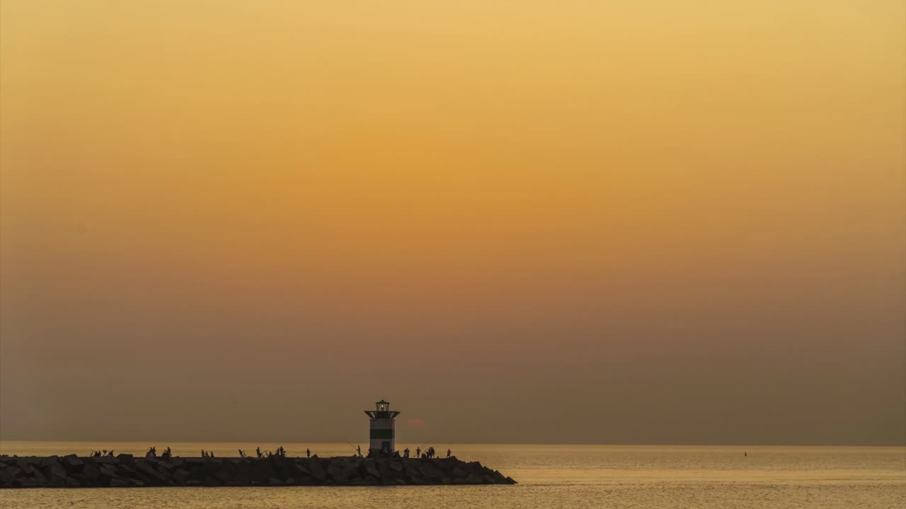 Tramonto sul faro del porto di Scheveningen nel giorno estivo più caldo di sempre