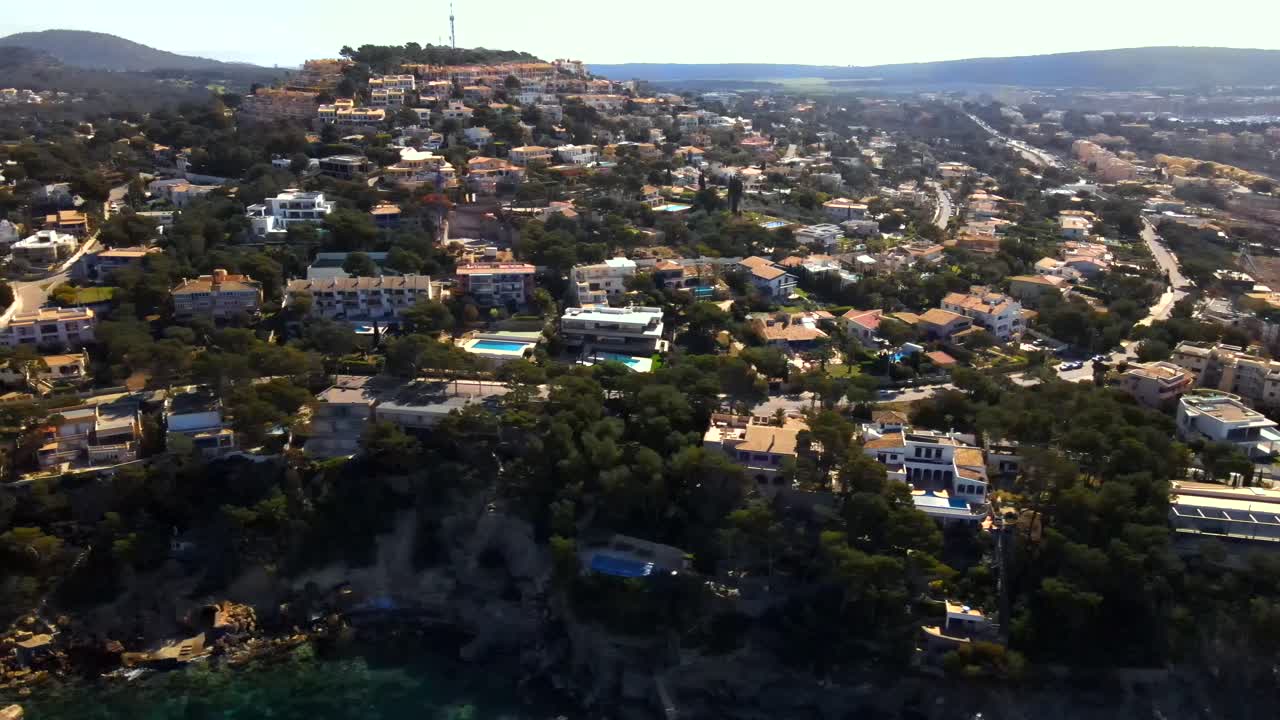 Explore the breathtaking landscape of Santa Ponsa, Mallorca. This aerial perspective highlights the charming villas, lush greenery, and the stunning coastline that define this popular destination.
