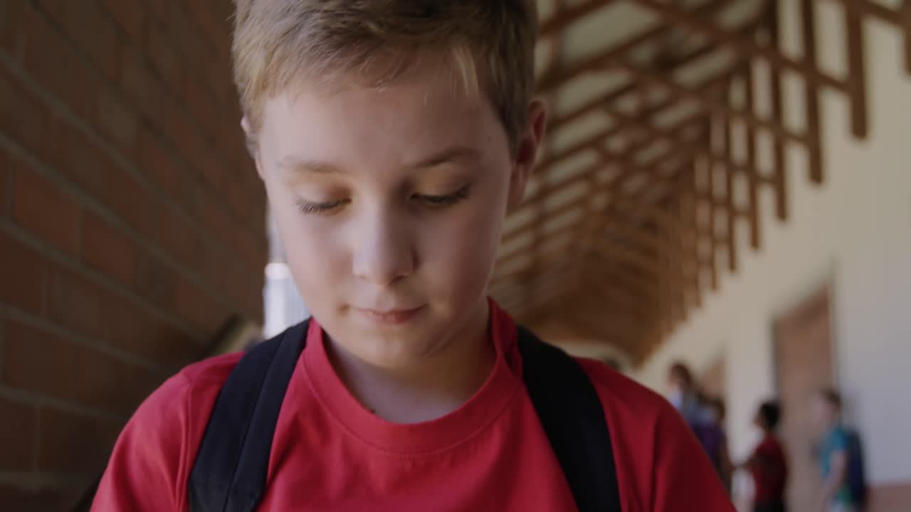 Ragazzo che usa lo smartphone nel corridoio della scuola