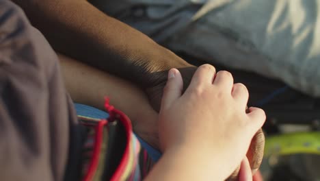 primer plano de una mano masculina tomando la mano de una mujer en silla de ruedas