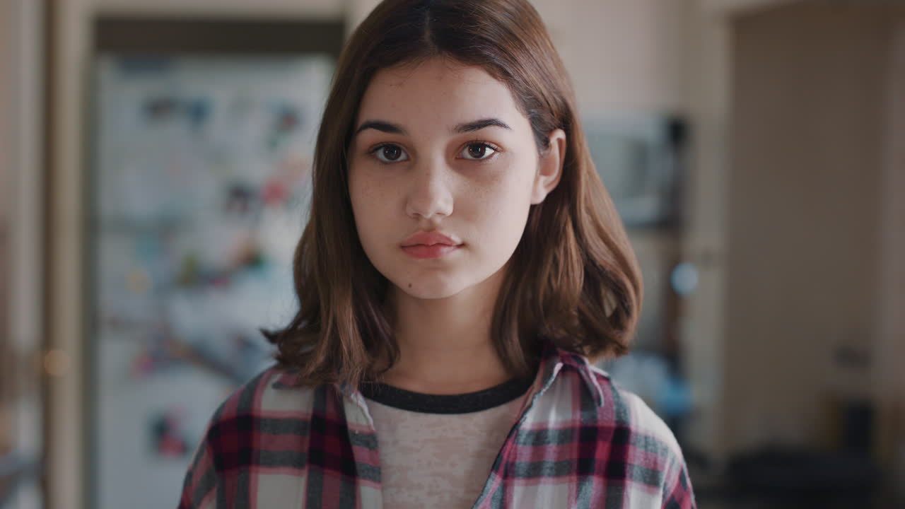 retrato de una hermosa adolescente en la cocina en casa buscando una expresión seria