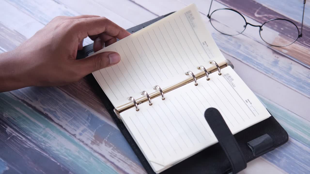 mano abriendo un cuaderno