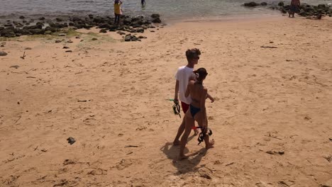 couple on a beach with snorkeling equipment
