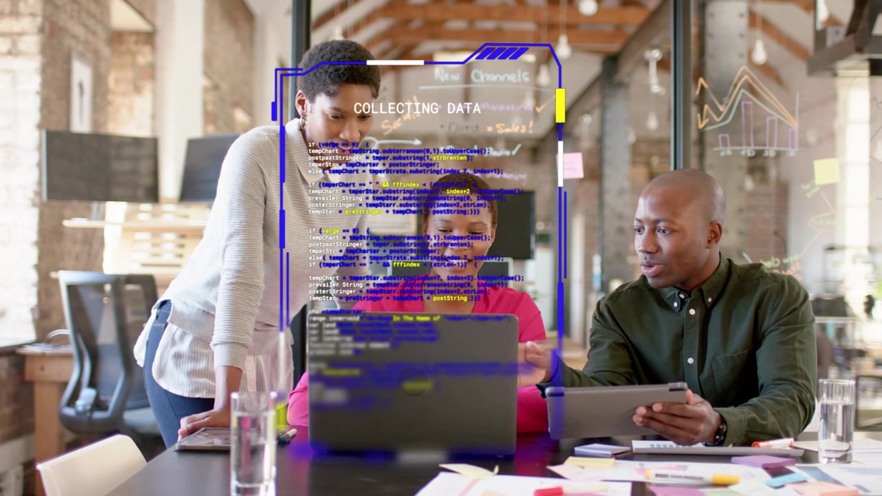 Seated woman starting typing on laptop bringing team sharing tablet checking tech overlay on laptop