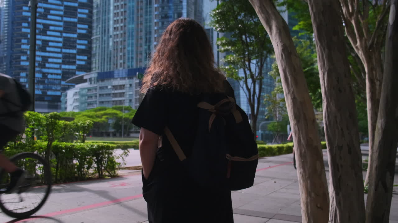 mujer caminando en una ciudad con rascacielos