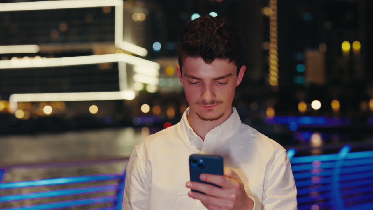Man using smartphone at night in the city