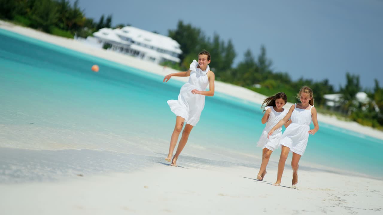Barefoot Caucasian girls walking together on tropical beach