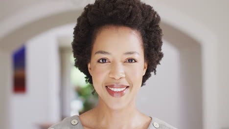 Portrait-of-happy-african-american-woman-with-short-hair-smiling-at-home,-slow-motion