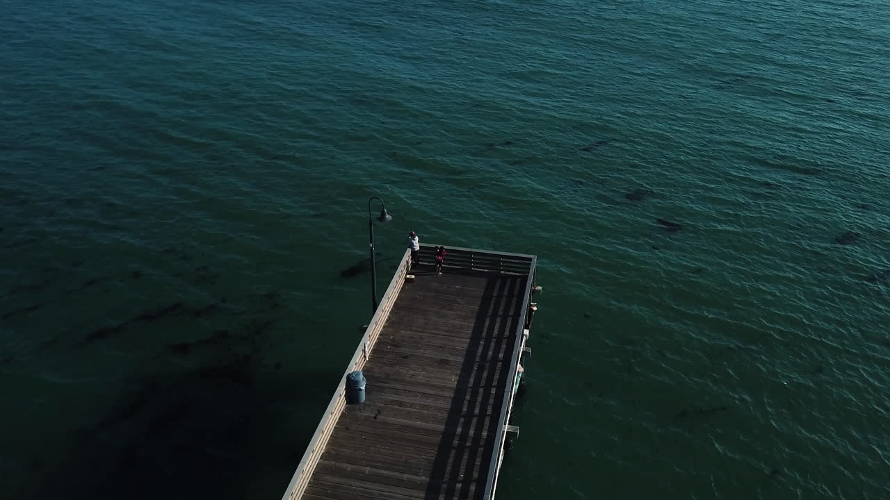 pescador al final del muelle mientras la cámara los rodea