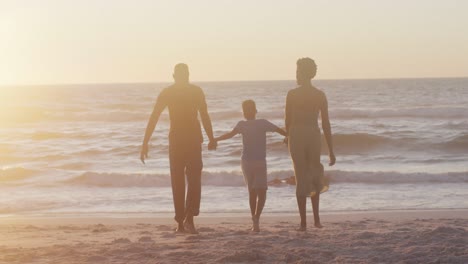 Video-Einer-Glücklichen-Afroamerikanischen-Familie,-Die-Bei-Sonnenuntergang-Am-Strand-Spaziert