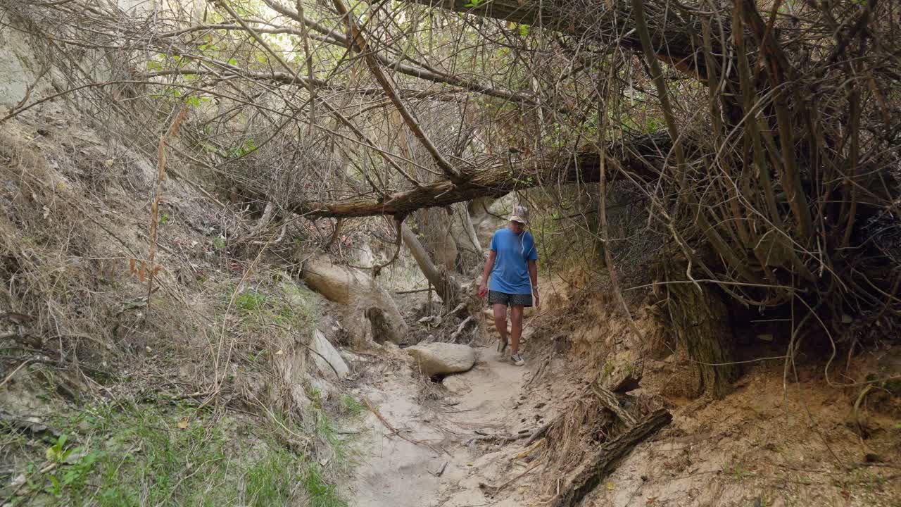una mujer excursionista explora la cueva de roca, el sendero del valle de las rosas, capadocia.