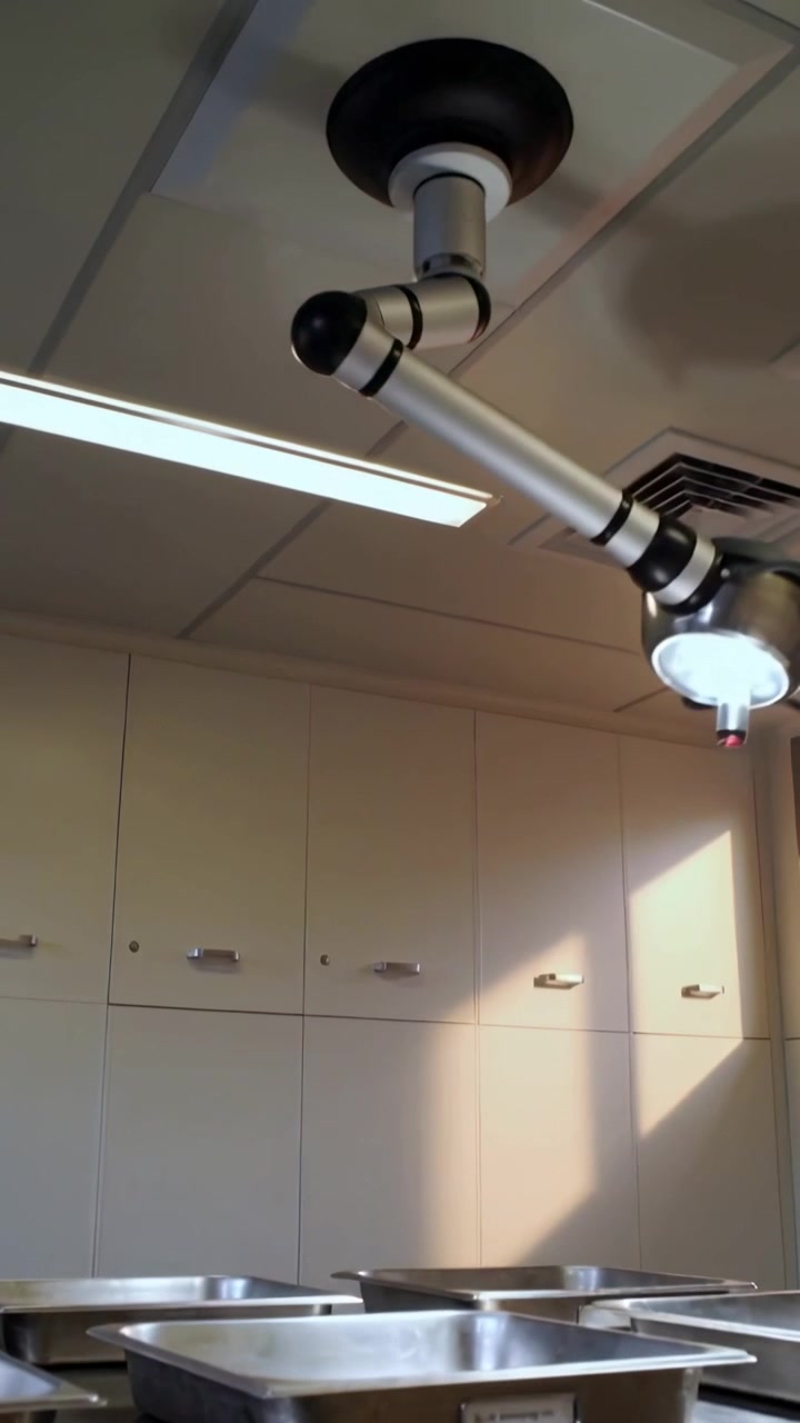 Vertical video: Tilting camera, articulated light rotating right in clinic lighting steel trays