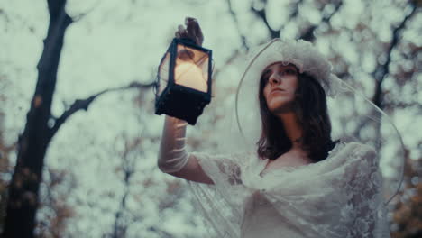 woman in white dress with lantern in forest