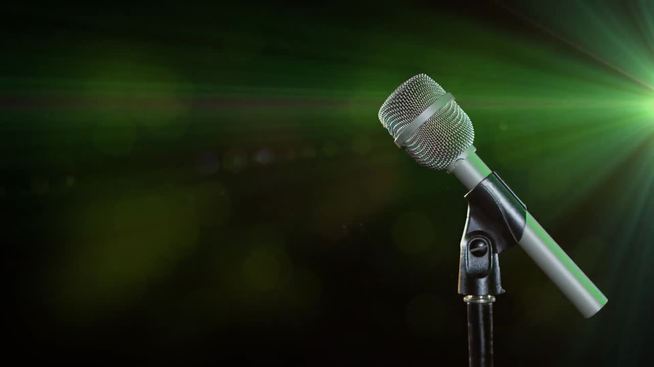 micrófono contra un punto verde de luz sobre un fondo negro