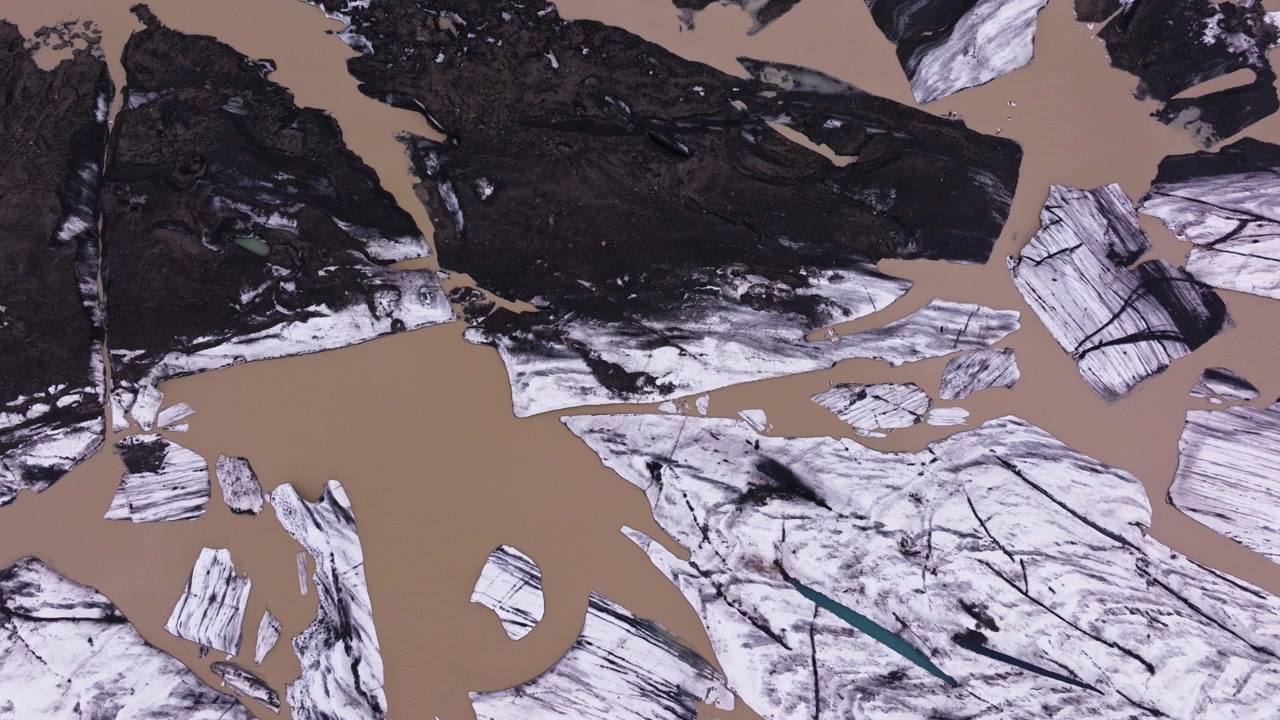 Brown water and dark ash by Hoffelsjökull glacier in Iceland, drone pan