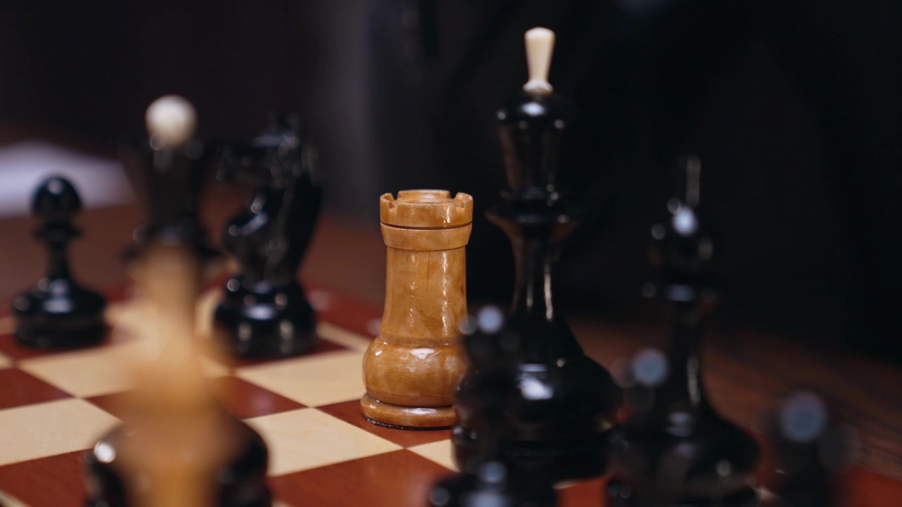 A Hand Moves a Wooden Rook Chess Piece on a Chessboard