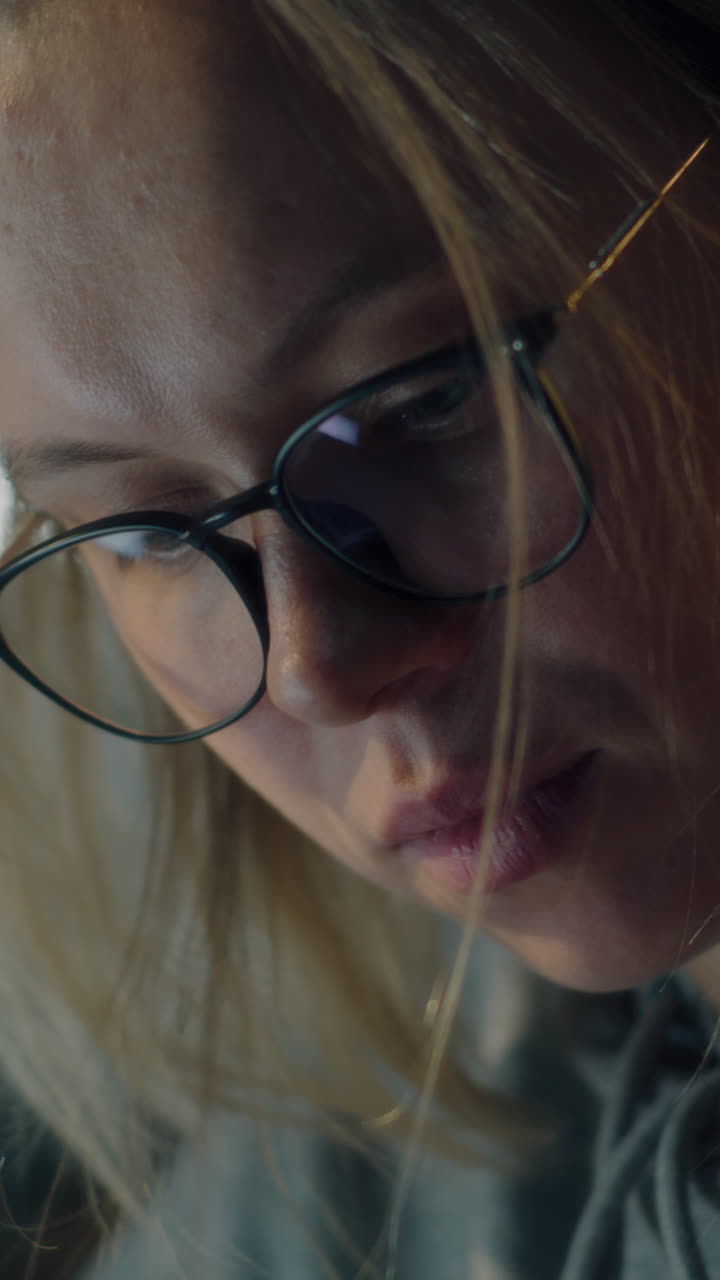 primer plano de una mujer con gafas y mirando hacia abajo