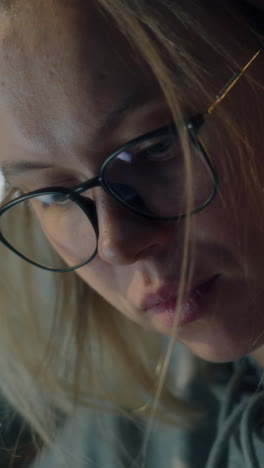 close-up of a woman wearing glasses and looking down