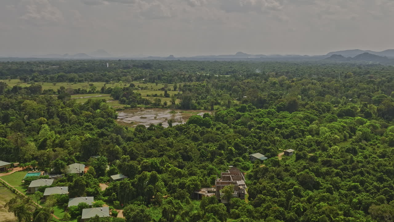 Sigiriya Sri Lanka Aerial v12 low flyover resort hotels capturing agricultural farming fields, lush tropical forests and landmark Sigiriya and Pidurangala Rock - Shot with Mavic 3 Cine - April 2023