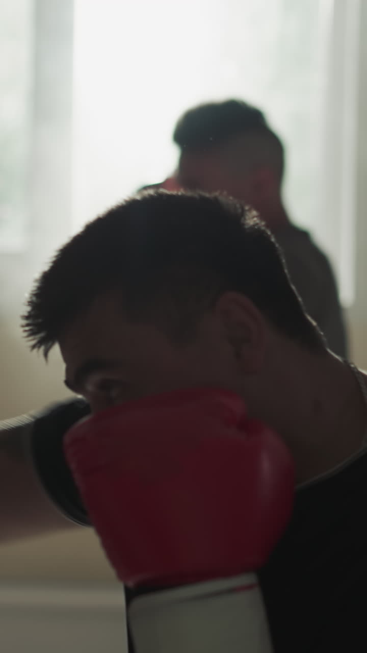 Sportsmen train with punching bags in gym. Martial arts masters exercise kicking and punching inventory in fighting club slow motion. Combat battle