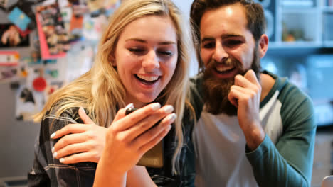 pareja sonriendo mientras usan el teléfono móvil 4k