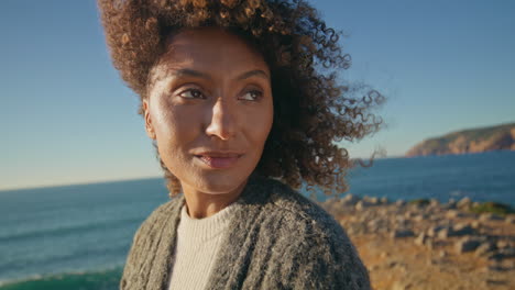 curly hair girl dreaming sea shore closeup. calm woman enjoying wind thinking