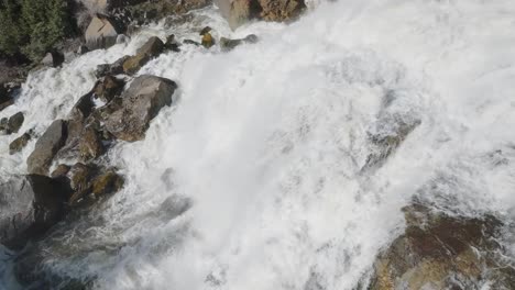 Rushing-waterfall-cascades-over-rocky-terrain-in-Owen-Sound,-Canada,-captured-from-above