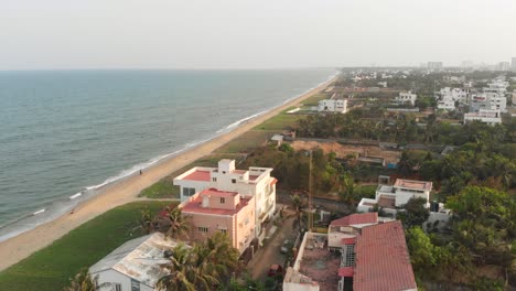 ECR-Chennai-Beach-Surrounded-By-Trees,-Construction-and-Buildings-Top-View-During-Sunset