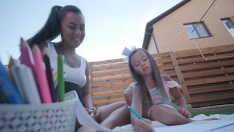 mother and daughter drawing outdoors