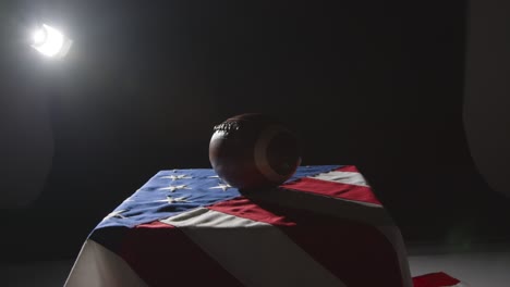 camera pushes in for close up studio shot of american football on stars and stripes flag 1