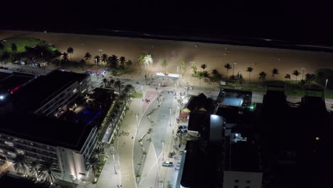 toma nocturna aérea giratoria de la plaza principal en el centro de tambaú con el letrero de la ciudad, un paseo marítimo a lo largo de la playa, restaurantes y apartamentos en la ciudad capital de joao pessoa, paraiba, brasil