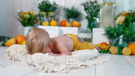adorable blond caucasian newborn with blue eyes. little kid trying to hold up his head. studio footage.