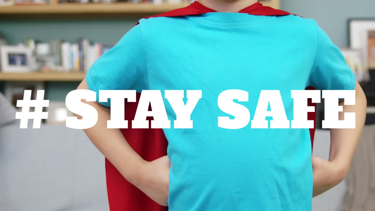 animación de las palabras # mantenerse a salvo sobre niño feliz con una gorra de superhéroe en casa.