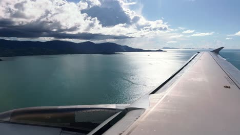 An-aircraft-flying-very-low-over-the-blue-ocean-towards-a-small-island-in-the-Gulf-of-Thailand